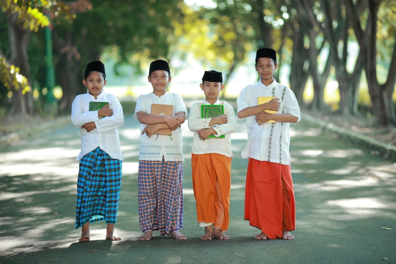 4 laki-laki berfoto memegang Al-Quran